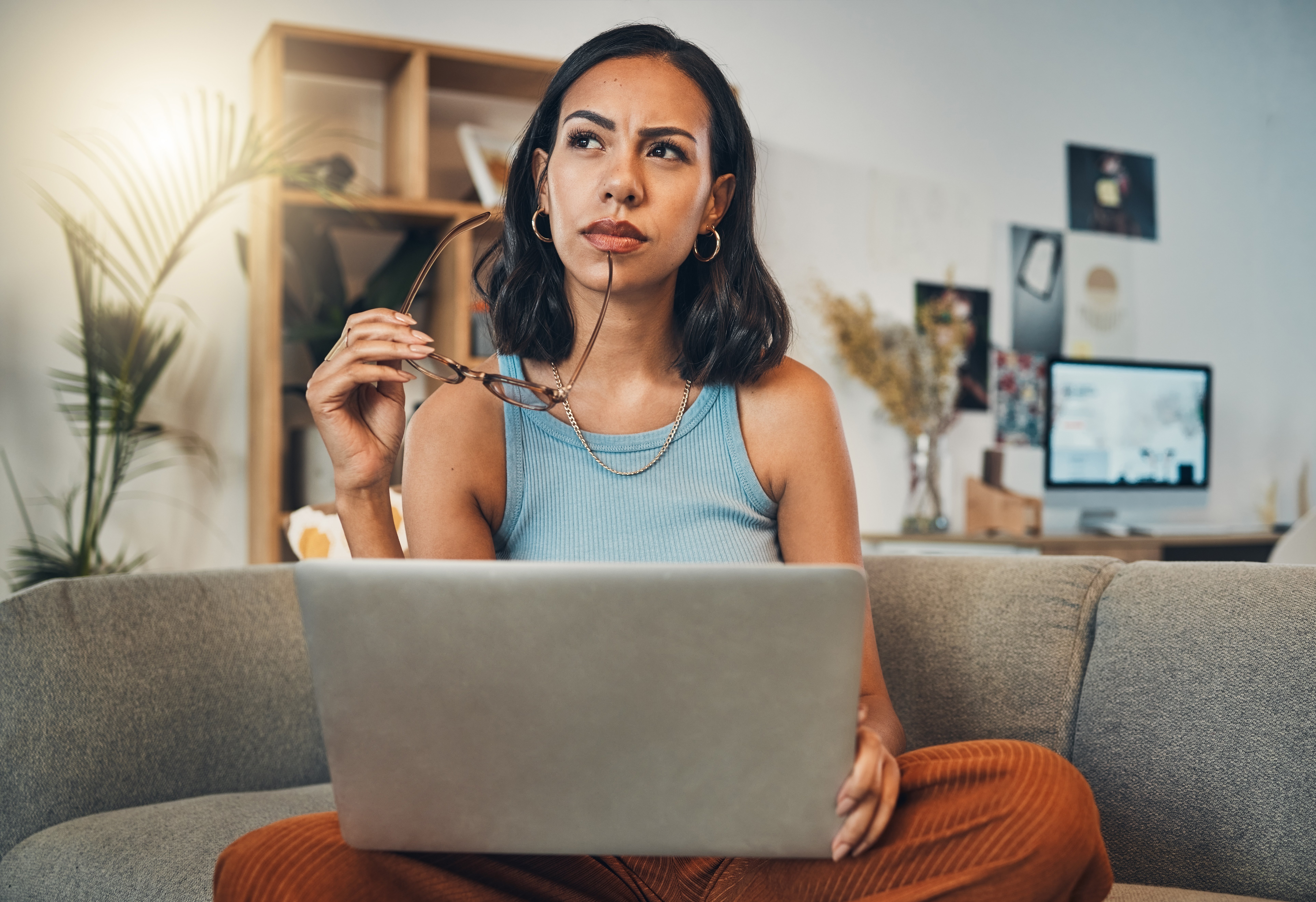 A woman thinking while using laptop